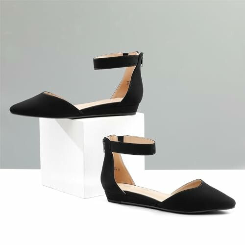 Black ankle strap flats displayed on a white box