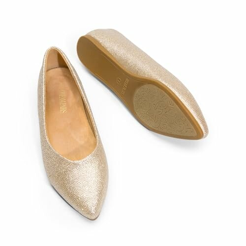 Pair of golden glittery ballet flats with pointed toes