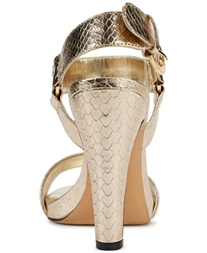 Rear view of a golden high heel shoe with a textured pattern.