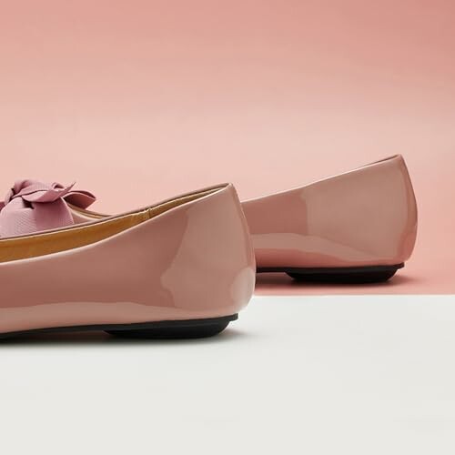 Pink ballet flats with a bow on a pink background