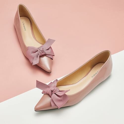 Pair of pink flats with bows on a two-tone background